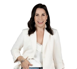 Professional headshot of a woman with dark wavy hair wearing a cream blazer and white top against a white background