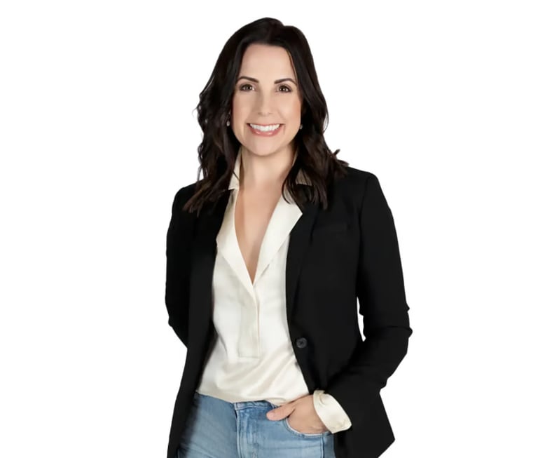 Professional headshot of a woman with long dark hair wearing a black blazer and white blouse against a white background